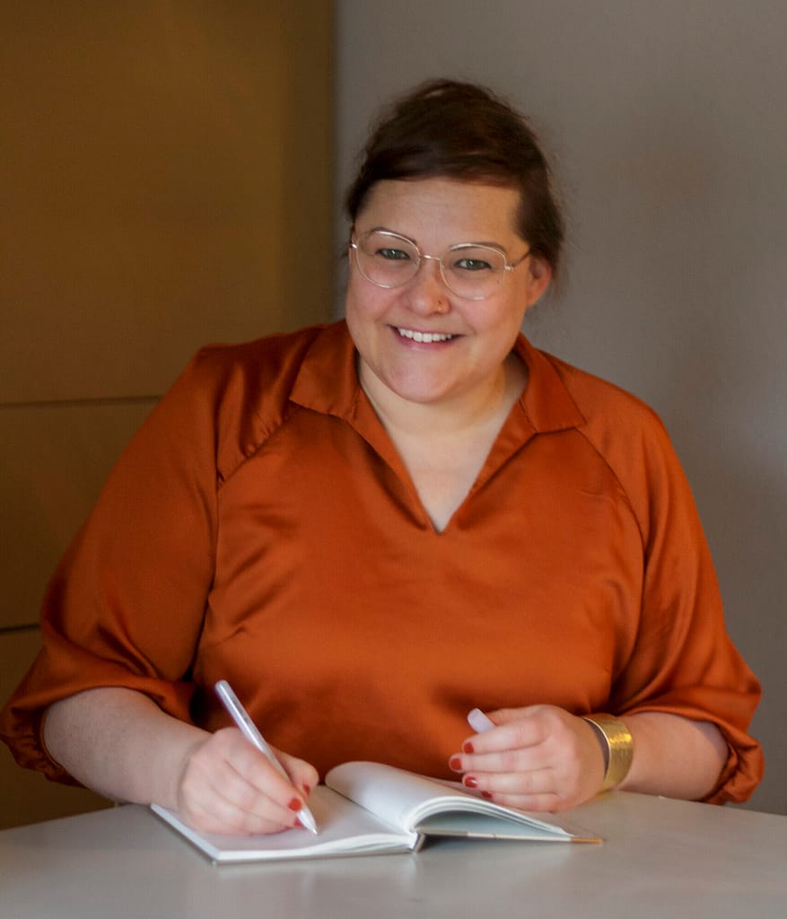 Ordnungscoach Frieda von WOHNE WUNDERBAR sitzt am Schreibtisch mit Kalender